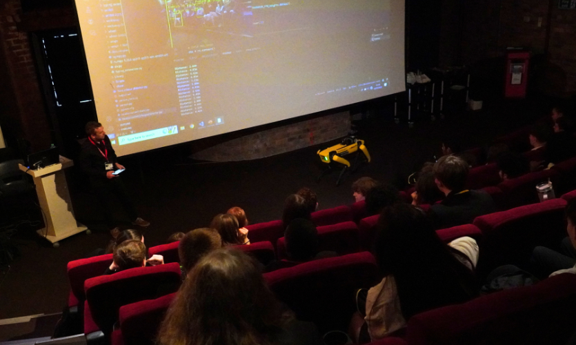 Dr Bezombes presenting to a lecture theatre of school pupils